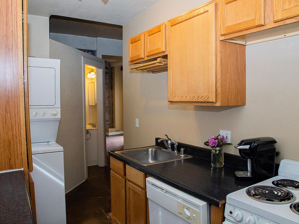 Kitchen with Stainless sink, electric stove, dishwasher and stacked washer dryer in unit.