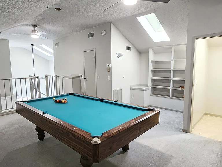 Spacious loft with pool table, skylight, bathroom, and bookshelf