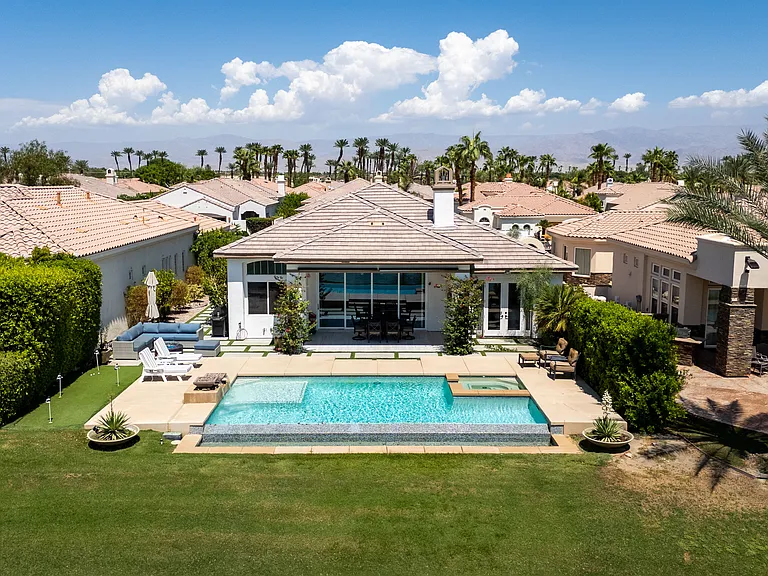 Resort style backyard with sparkling pool, warm spa, and beautiful golf course backdrop.