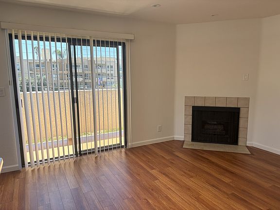 Living room with fireplace, sky light, balcony and view.