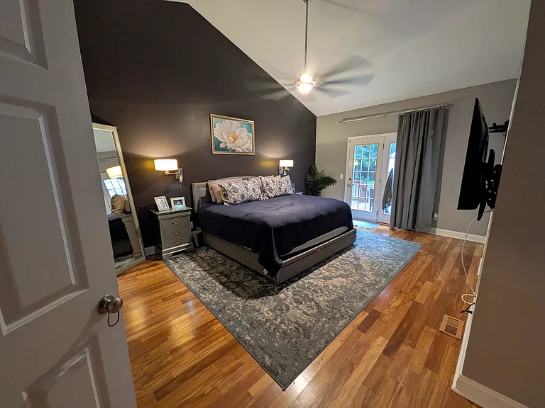 Primary Bedroom
Spacious primary bedroom with vaulted ceilings, a large ceiling fan, a walk-in closet, and flexible space currently used as a reading nook. Direct access to the back porch adds a great connection to the outdoors.