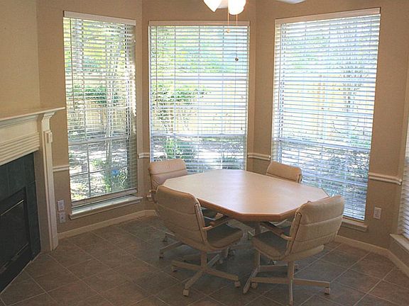  The breakfast room has one side of the two-sided fireplace and a bayed window looking out to the backyard.
