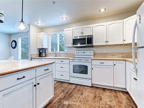 Kitchen with generous storage and counter space features new microwave and tile counters.
