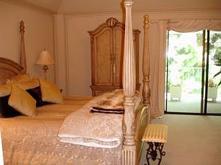 master bedroom with balcony patio overlooking pool
