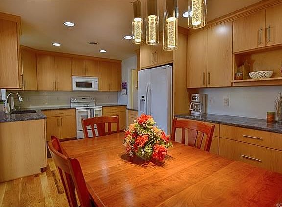 The kitchen has been renovated with modern touches offering granite countertops, deep granite sink. maple cabinets complete with modern hardware and hardwood floors complete this spacious kitchen.