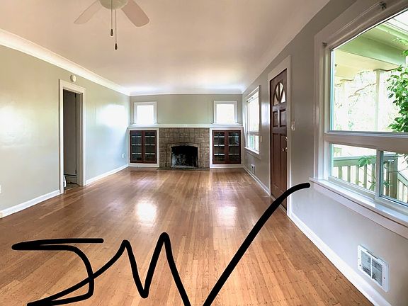 Front room with Leaded Glass cabinetry around fireplace. Hardwood floors. Overhead ceiling Fan. Mini-Split for Heating and A/C.