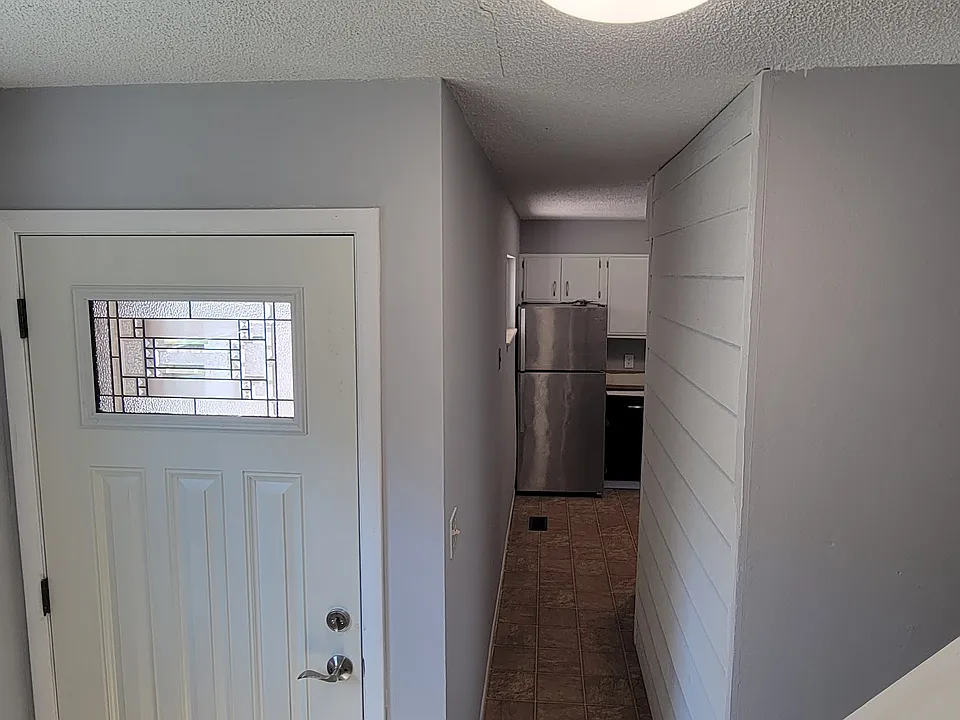Looking at the front door and hall to the kitchen from the stairs