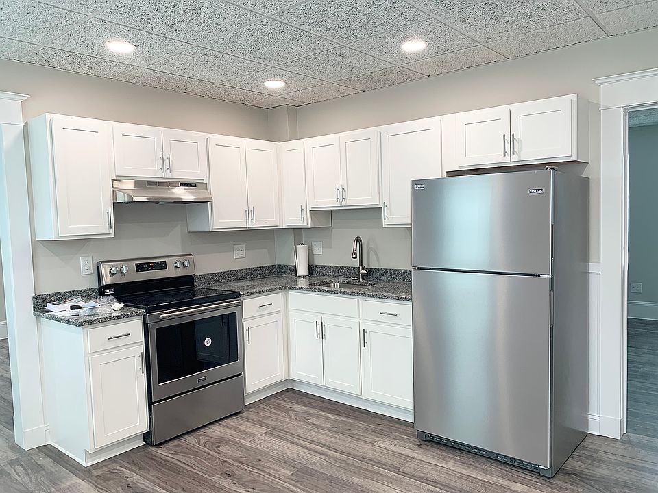 Stainless steel appliances and new white cabinetry, recessed lighting