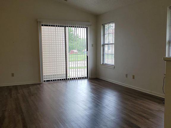 Large living room with vaulted ceiling and open floor plan to kitchen, dining and side patio.