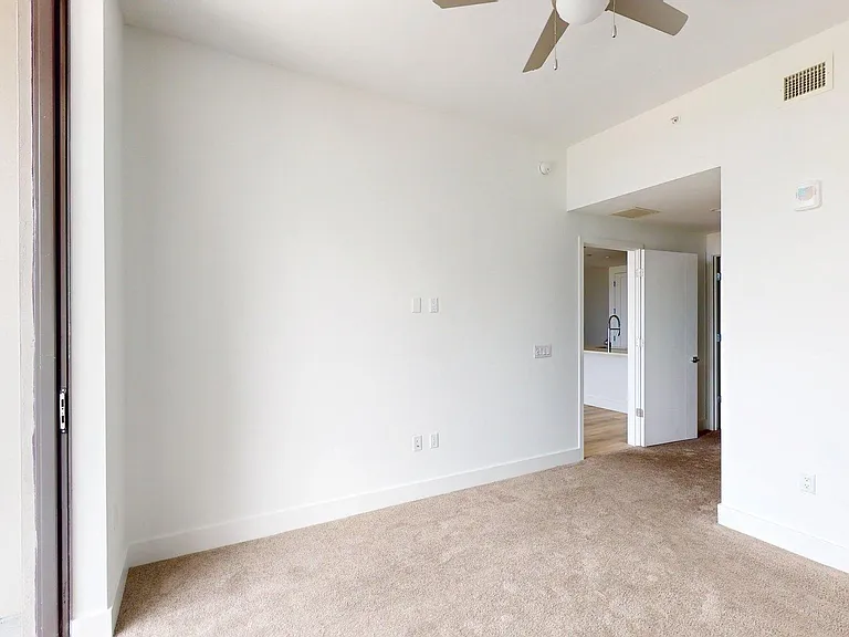 Spacious apartment Bedroom with carpet flooring.