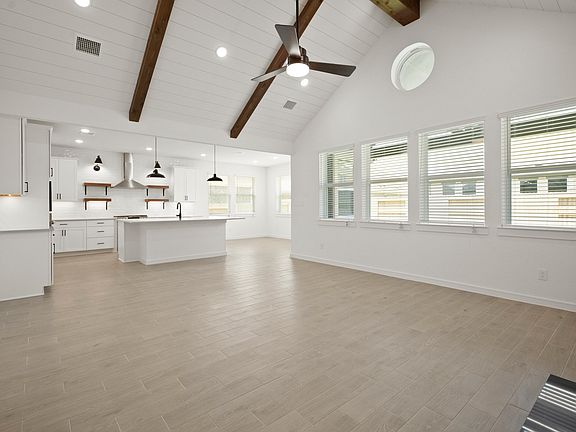 Great room features soaring vaulted ceiling with stained beams shiplap detail