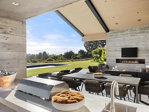 Savor the all-encompassing experience on the outdoor patio, complete with a dining table, outdoor lounge, TV, fireplace, sunbeds, and breathtaking ocean views.