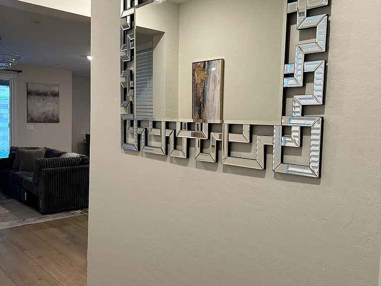 Open hallway entry with wood-look flooring and a wide wall space ideal for decor, leading into the main living area.