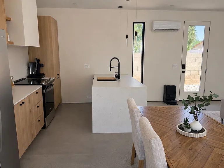Stylish, fully equipped kitchen with custom cabinetry, stainless steel appliances, and minimalist design touches.