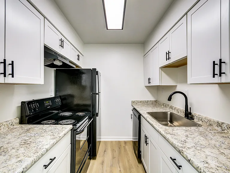 White cabinetry and black appliances accentuate this bright, newly renovated kitchen at ReNew on Cantrell.