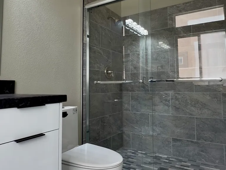 Office bathroom featuring glass-enclosed walk-in shower