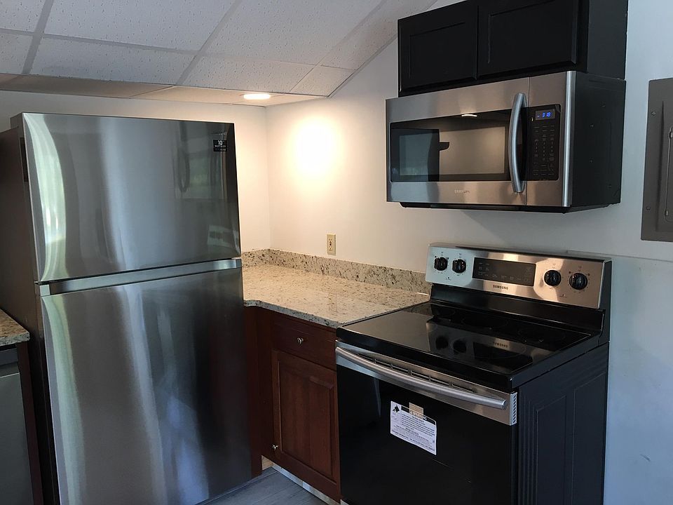 Right side of kitchen, new refrigerator, glass top stove and microwave