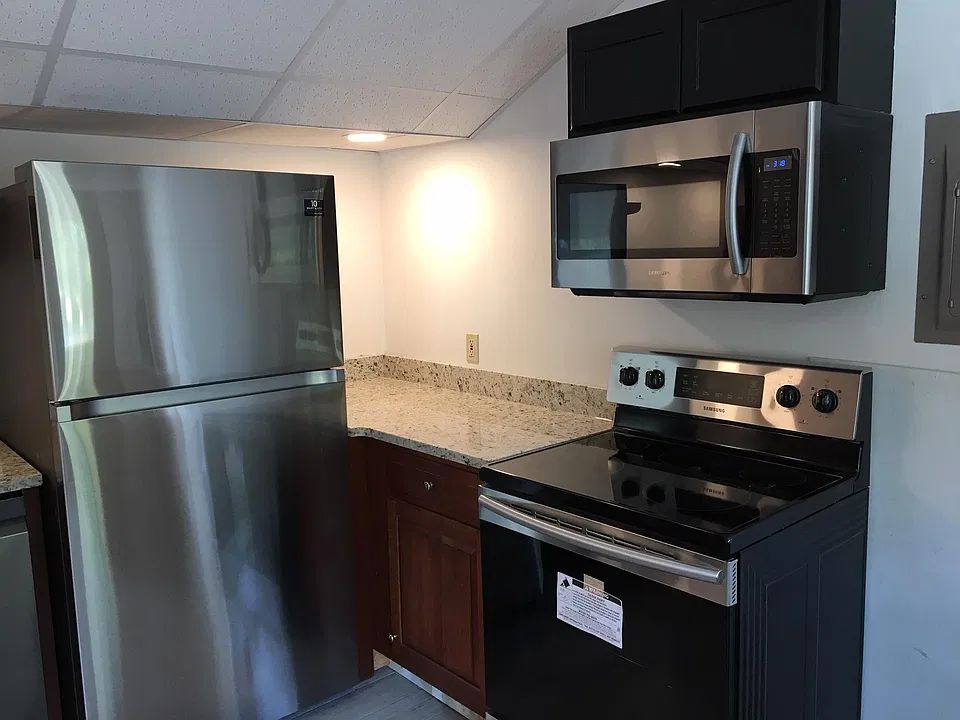 Right side of kitchen, new refrigerator, glass top stove and microwave