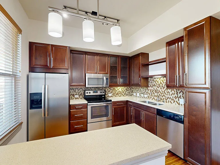 Apartment Kitchen with Quartz counter tops and Wood Style Flooring.
