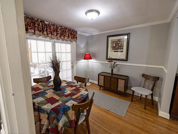 Shows dining room, and beautiful hardwood floors.