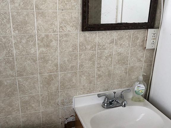 Bathroom with newer vanity and commode. Ceiling exhaust fan as well as full operational window.