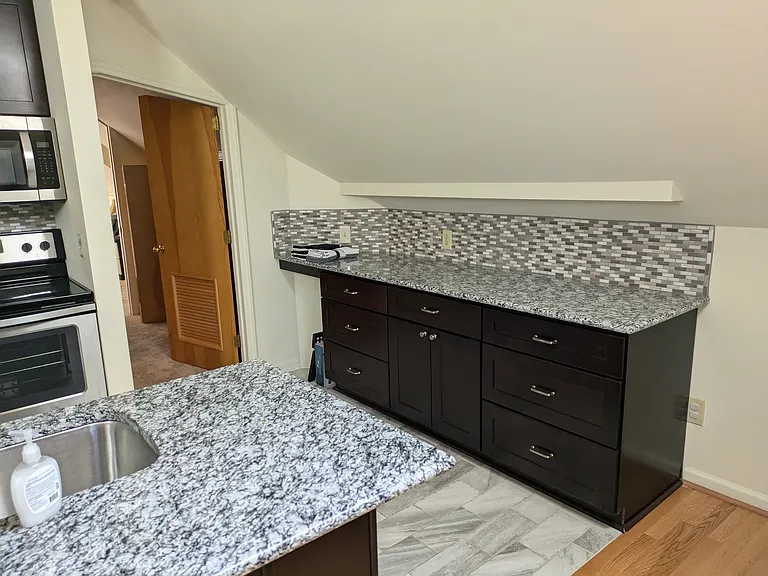 Kitchen area, granite counters, hall leading to bathroom and bedrooms
