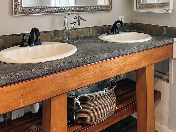 Bathroom: double sink concrete vanity, open shelf