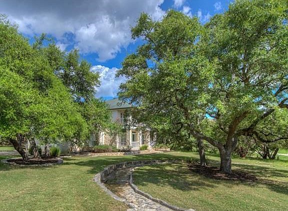 The home is surrounded by large mature oak trees.
