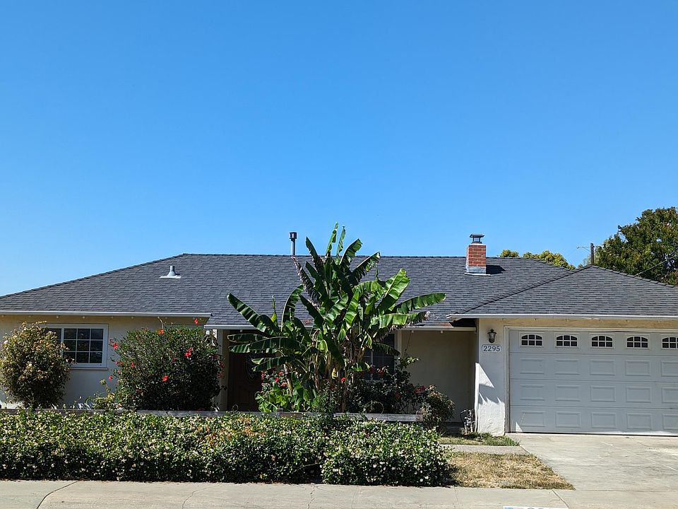 Beautifully landscaped front yard with lush hibiscus and vibrant banana plants, creating a tropical paradise and welcoming curb appeal