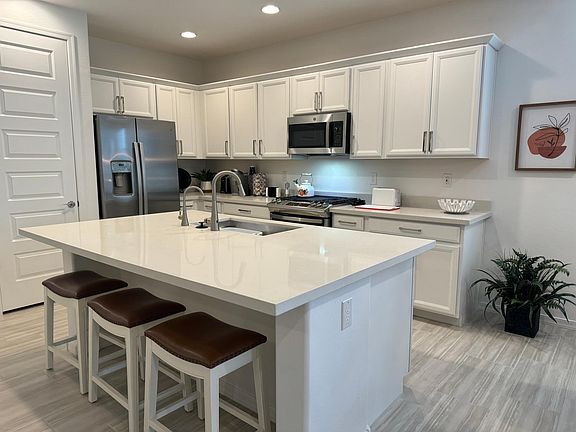 Kitchen with island and breakfast bar seating for three