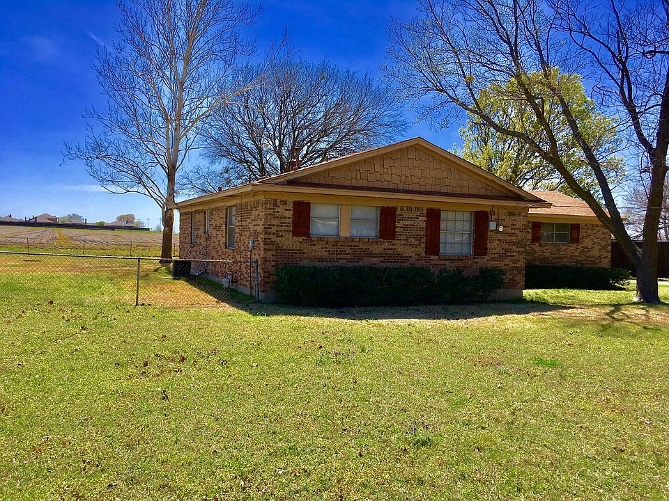 Front of home with fenced in back yard and side yard.