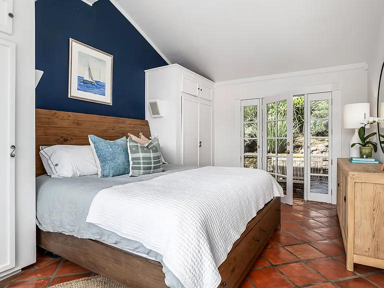 Primary Bedroom with King Bed and En Suite Bathroom featuring private entrance from back garden and patio.