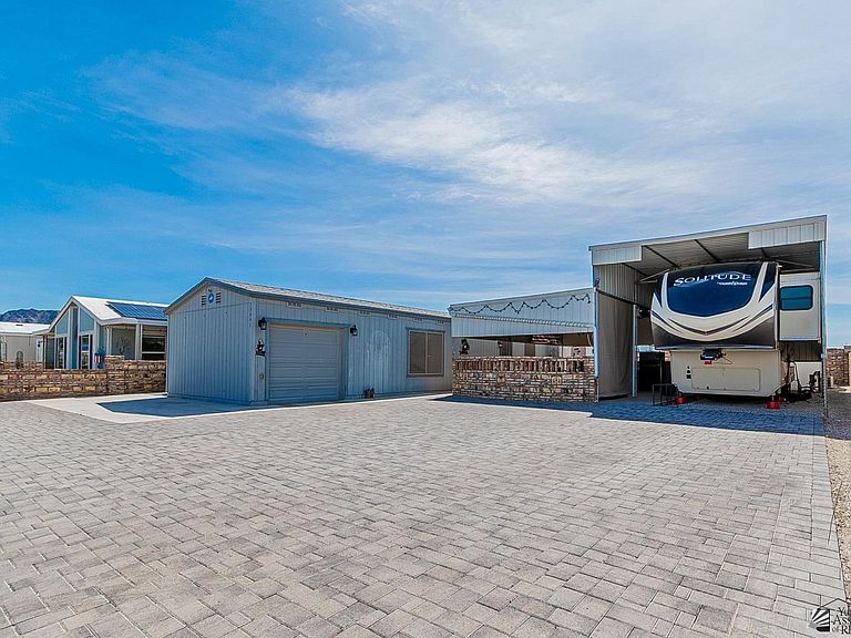 Front of the home with paver drive and covered RV parking