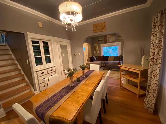 Dining room, stairs leading up to bedrooms. Living room visible in the distance