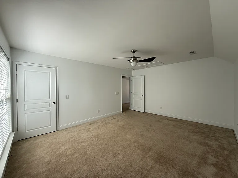 Spacious second-floor bedroom offering a clean, quiet layout with ample wall space for furniture, built-in closet storage, and crisp white trim details."