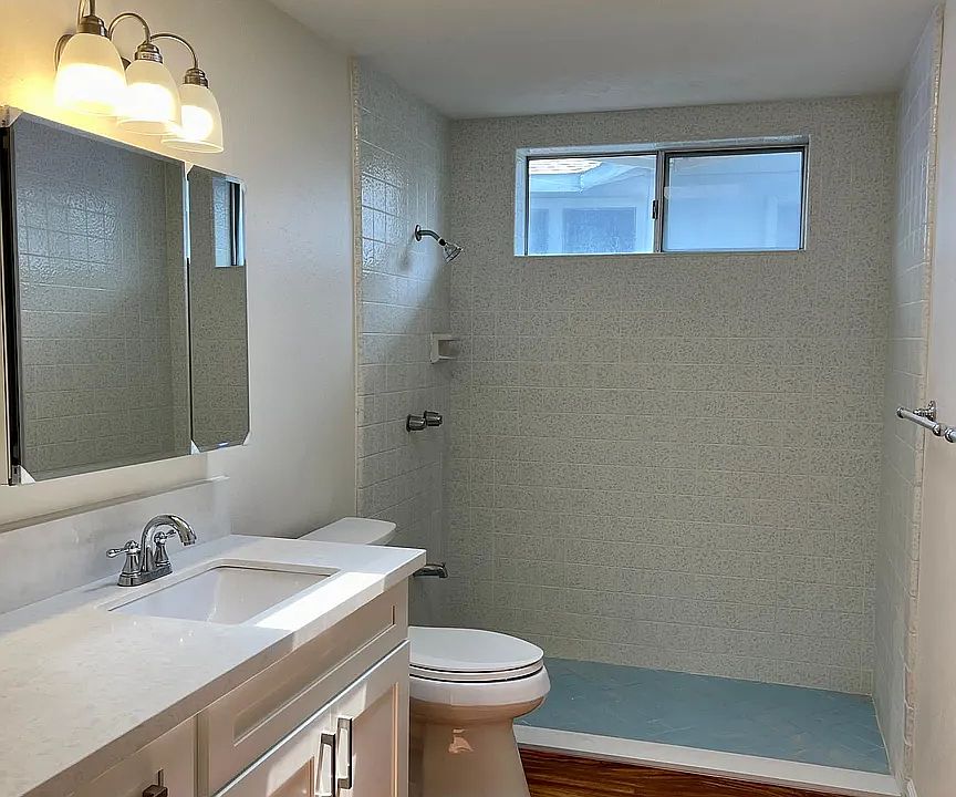 Large remodeled bathroom with skylight, new vanity cabinet, mirrored-medicine cabinet, toilet, flooring, walk in shower
