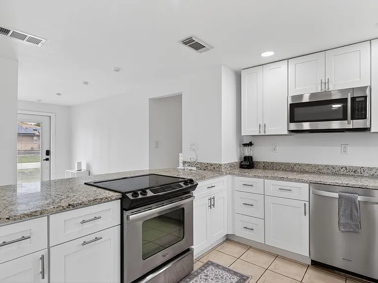 Updated kitchen with stainless-steel appliances including a microwave & dishwasher.