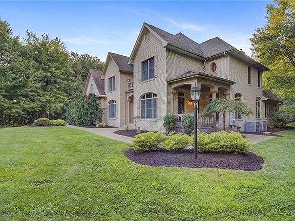 A covered side porch offers access via French doors to the main level office.