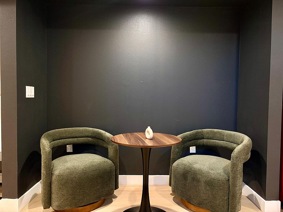 Small lounge nook with two upholstered swivel chairs and a bistro table, ideal for reading or casual conversation.