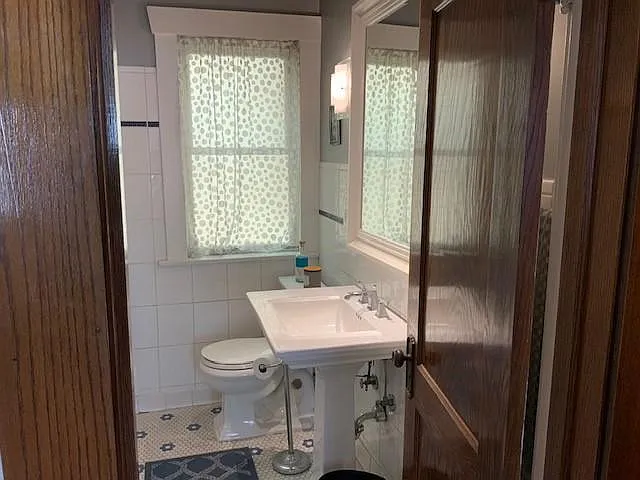 Bathroom with fully tiles floors/walls in contemporary colors.