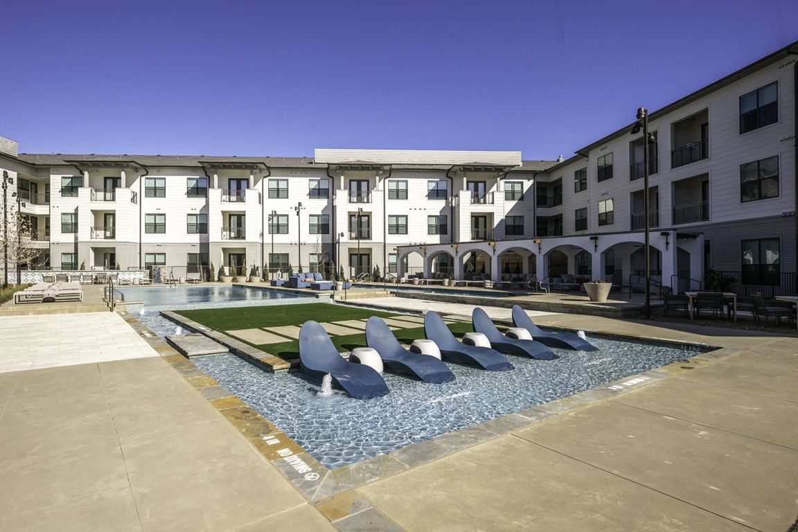 Experience ultimate relaxation with in-pool seating at Modera Walsh's expansive pool.