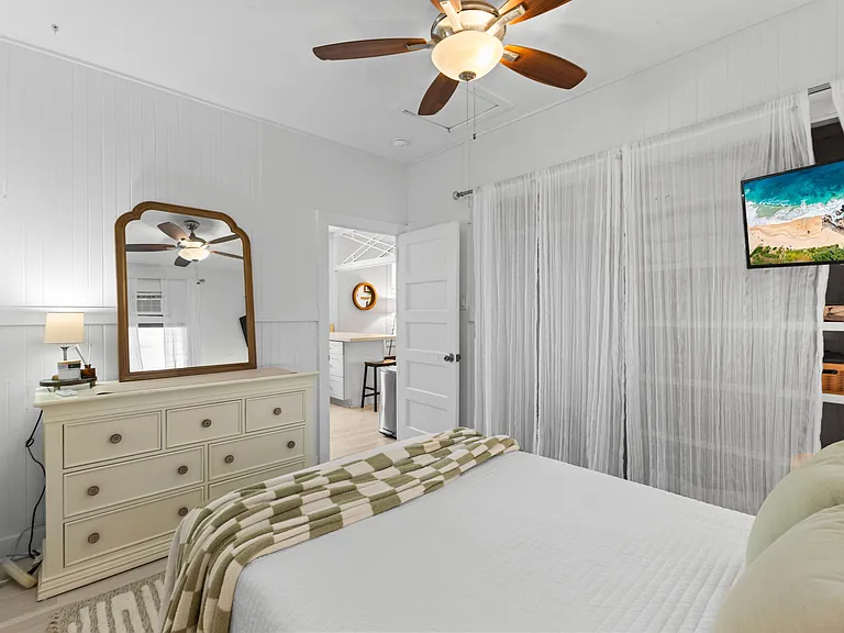 Back bedroom with double bed, AC, ceiling fan, dresser, side tables and large closet with built-in shelving.
