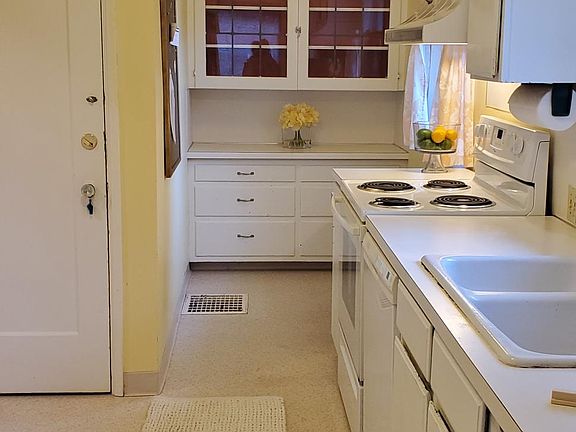 Kitchen painted white with new refrigerator, full size dishwasher and oven/stove