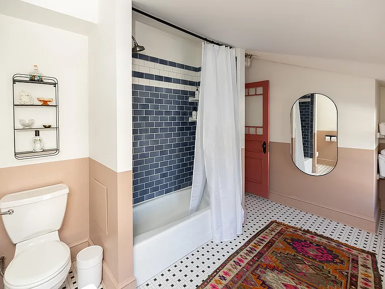 Unwind in our whimsical bathroom with a funky twist. ___ Whether you're looking to soak away the day's stresses or freshen up for a night out, our bathtub is the perfect spot. Take your time and pamper yourself in this unique and cozy space. ____