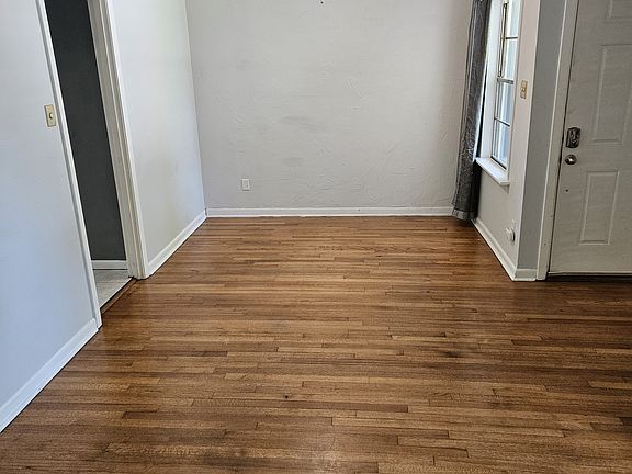 Living room. Hardwood floors. Dining area ahead beneath the ceiling fan.