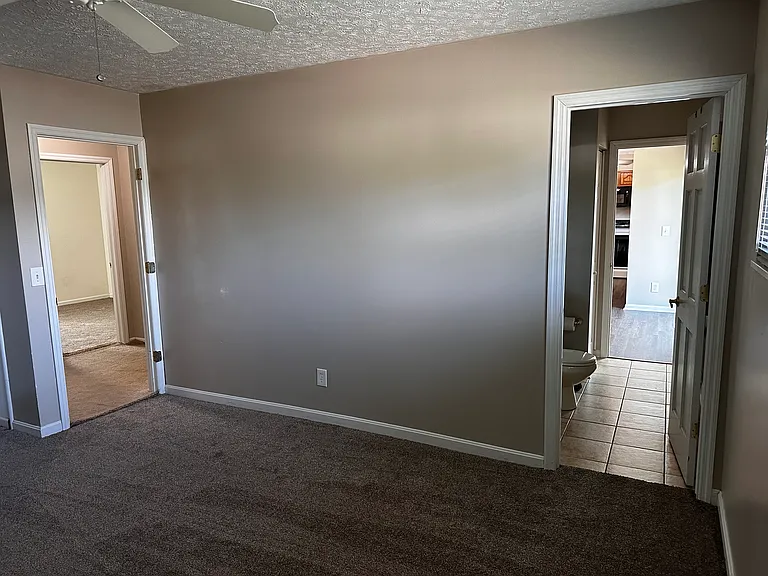 Master bedroom door on left to hall, switched plug, and door on right to half bath with a second door into the dining and kitchen area.
