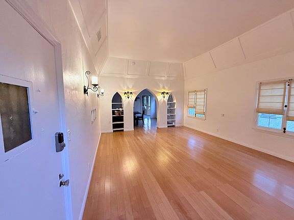 Living Room. HDMI & ethernet jacks between windows for TV. Jacks lead to built in shelves for devices, router, etc.