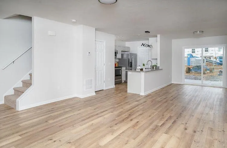 A nice perspective of the first floor. Living room, dining, and kitchen areas. Open floor arrangement with windows on both front and backside. Also in the middle is the door to the half bathroom on this floor. You can also see the back double door that le