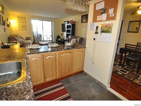 New kitchen with stainless steel appliances including a dishwasher, microwave, range and French door refrigerator.  The wall has been opened to create a breakfast bar and allow light from the living room.