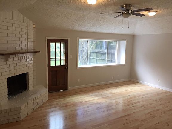 Large Open living room with fireplace, large windows, new pa